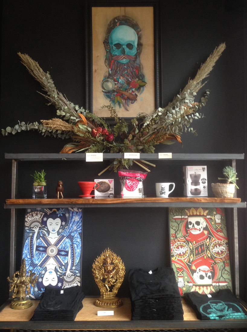 dried greens arrangement under a portrait of a skull